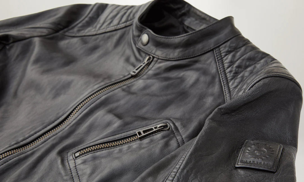 Close-up of a black leather jacket with a zipper and pocket on a light gray background