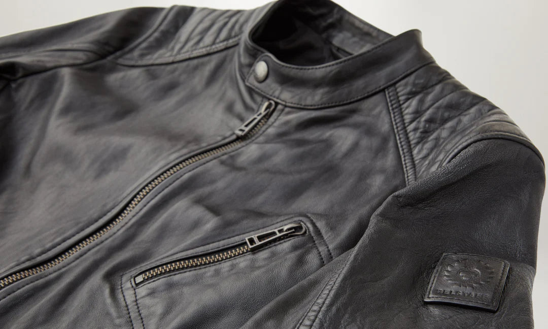 Close-up of a black leather jacket with a zipper and pocket on a light gray background