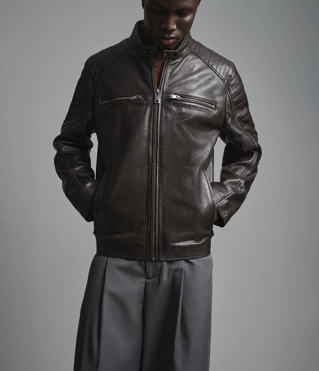 Man wearing a dark leather jacket on a gray background