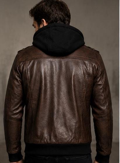 A man viewed from behind wearing a brown leather jacket with a black hood attached at the neck, set against a neutral gray studio background.